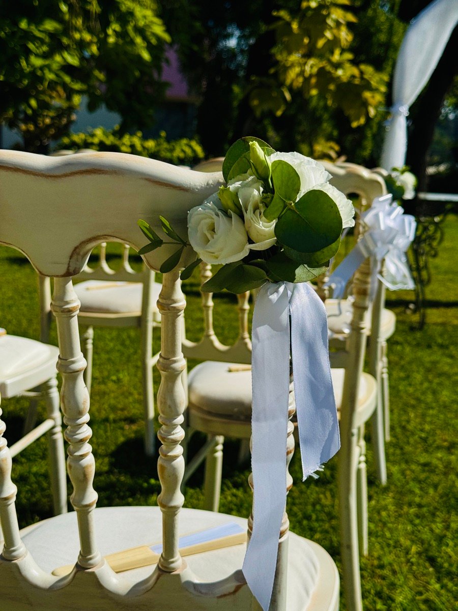 Sedie eleganti decorate con fiori bianchi per cerimonia ed eventi aziendali